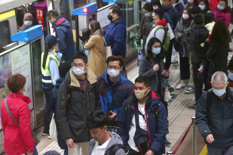 Passagiere in Taiwan tragen Mundschutz in einer U-Bahn-Station.
