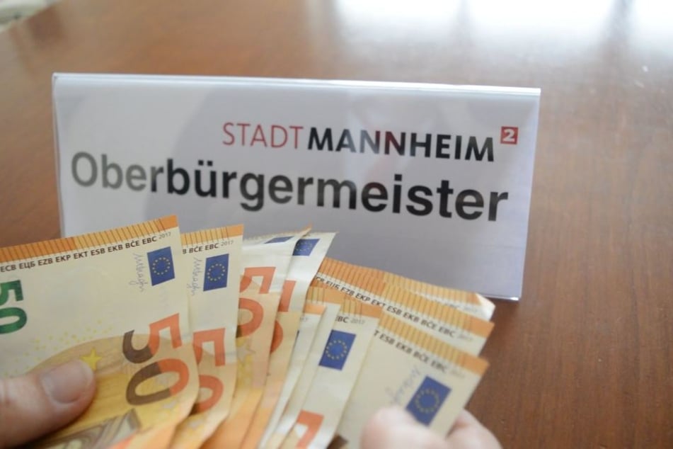 Außerdem wird Oberbürgermeister Kurz beim Geldzählen gezeigt.