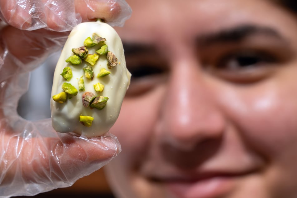 Evin Karaaslan, Mitarbeiterin bei Hasat Nuts, zeigt ein Stück Weiße Schokolade-Datteln mit Pistazien und Kadayif (Engelshaar).