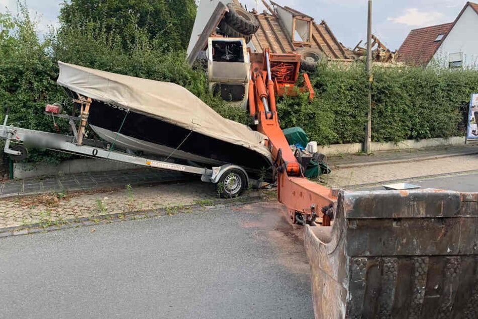 Der Bagger durchbrach die Hecke und krachte auf das Boot am Straßenrand.