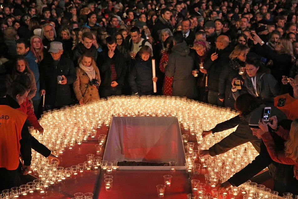 Besucher des Lichtfestes Kerzen in eine überdimensionale 89 auf dem Leipziger Augustusplatz.