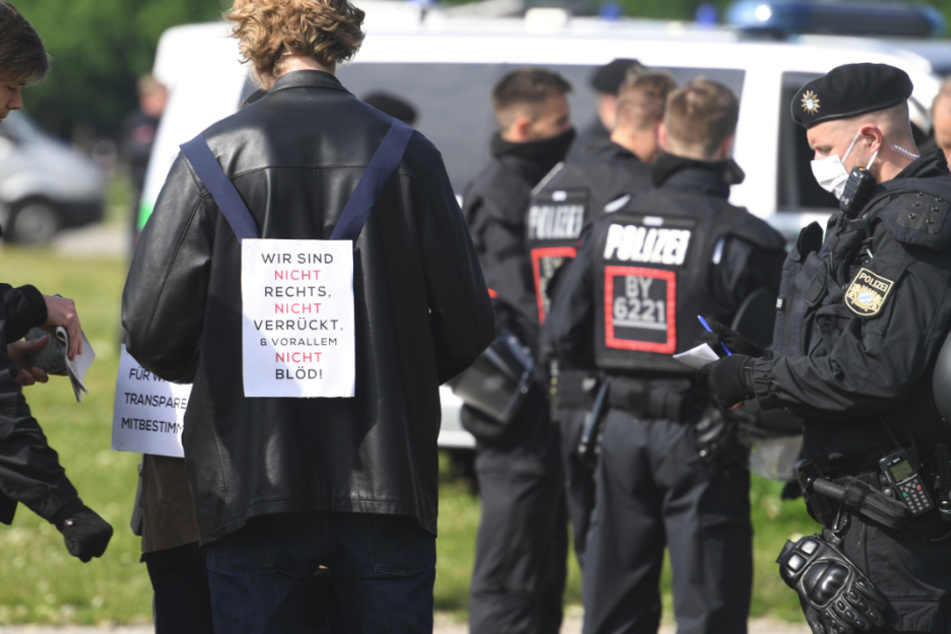 Ein Teilnehmer einer Demonstration gegen die Anti-Corona-Maßnahmen steht auf der Theresienwiese.