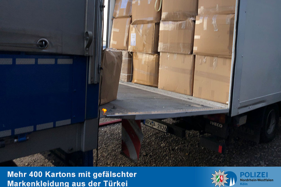 Drei Lastwagen für den Abtransport: Die Kölner Polizei fand Hunderte Kartons gefälschter Markenkleidung und stellte sie sicher.