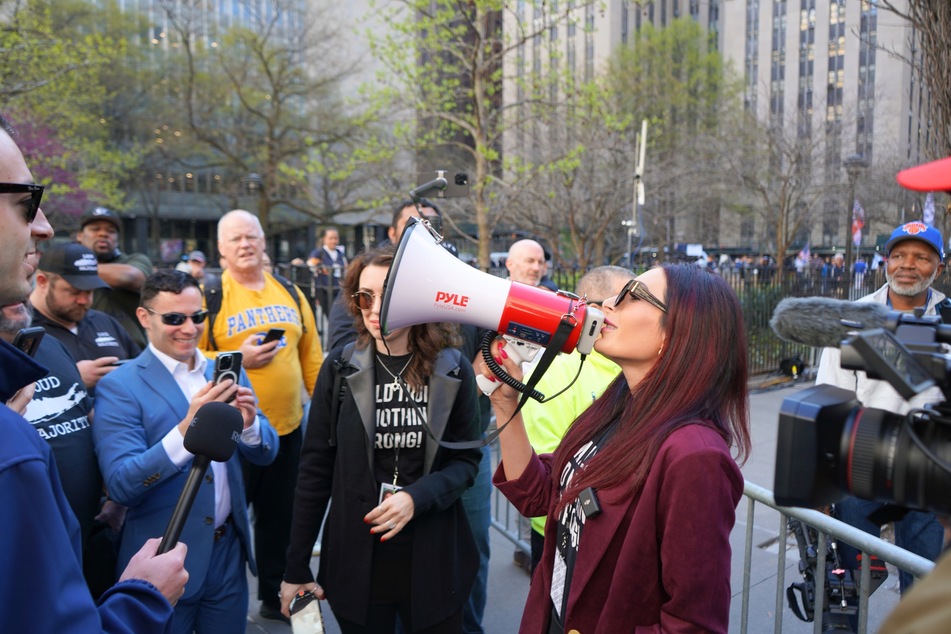 Far-right provocateur Laura Loomer using a megaphone to spark the chant, "Donald Trump did nothing wrong" among a small crowd of Trump supporters.