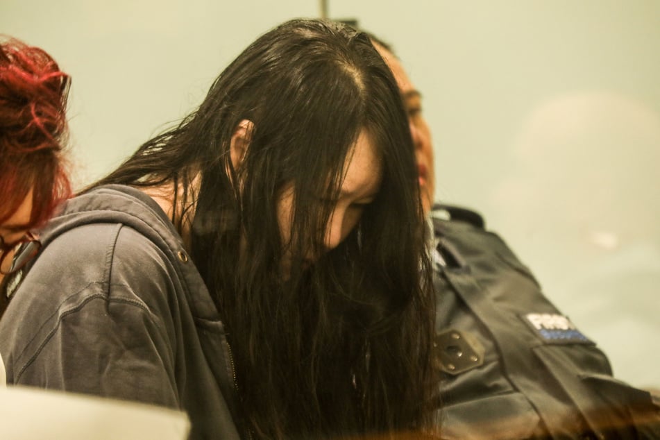 Mit gesenktem Kopf schreitet Lee zur Anhörung.