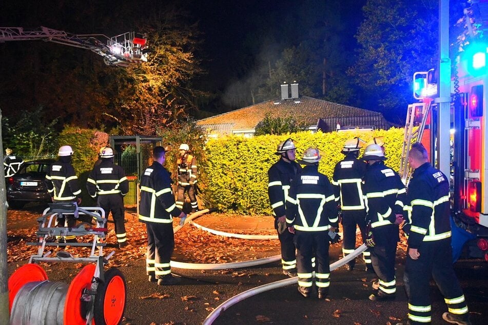 Einsatzkräfte der Feuerwehr stehen an der Einsatzstelle in Hamburg-Eißendorf.