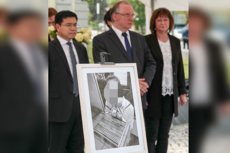 Während einer Veranstaltung in Gedenken an Yangjie Li standen Sachsen-Anhalts Ministerpräsident Reiner Haseloff (M.) mit seiner Frau Gabriele und dem chinesischen Botschaftsrat Qinghua Zhao hinter ihrem Bild.
