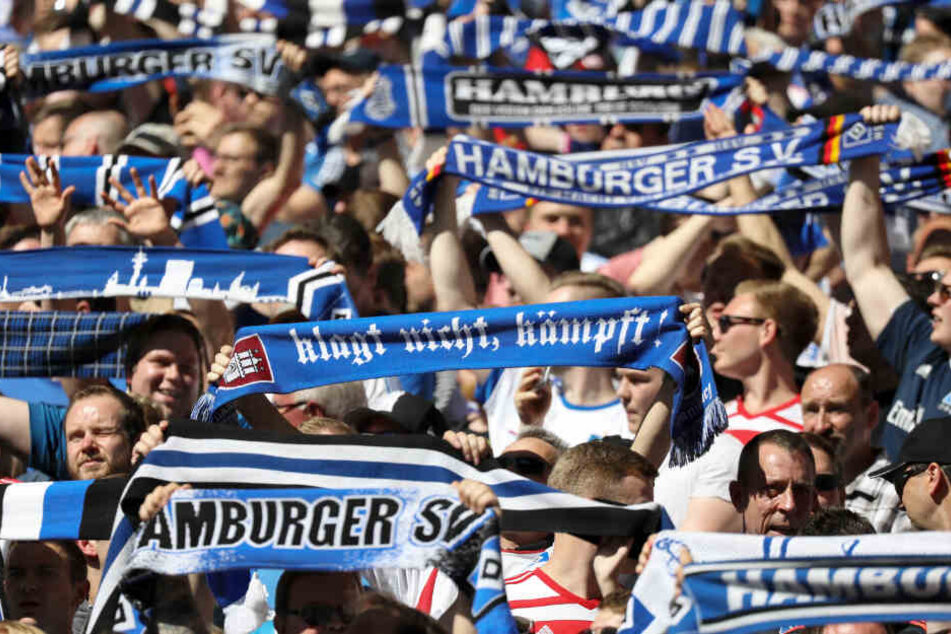 Die Fans des Hamburger SV halten ihre Schals in die Höhe.