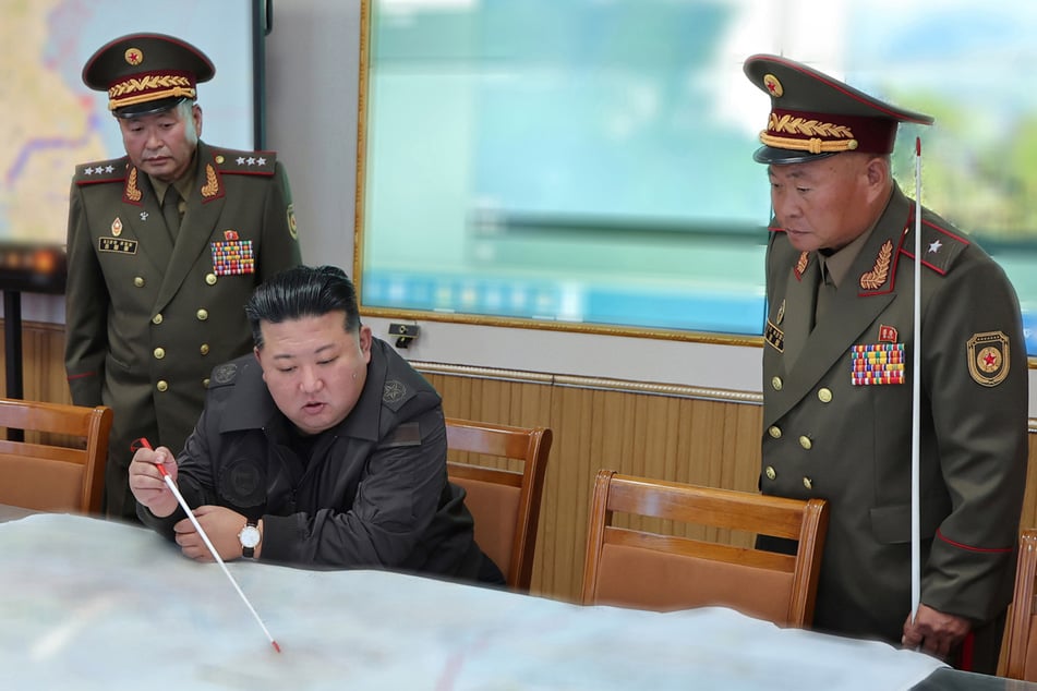 Dieses von der staatlichen nordkoreanischen Nachrichtenagentur Korean Central News Agency (KCNA) zur Verfügung gestellte Foto zeigt Kim Jong Un (M), Oberster Führer von Nordkorea, der mit Offizieren während eines Besuchs im Hauptquartier des 2. Korps der nordkoreanischen Armee spricht. (Archivbild)