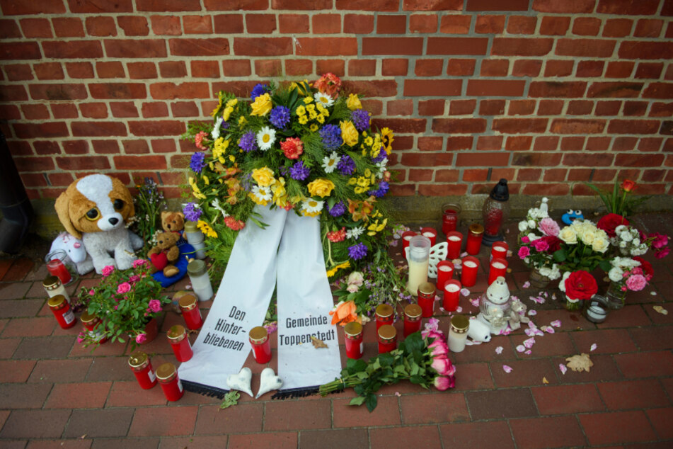 Blumen, Stofftiere und Kerzen liegen nach dem tödlichen Radlader-Unfall in Toppenstedt vor dem Haus der Gemeindeverwaltung.