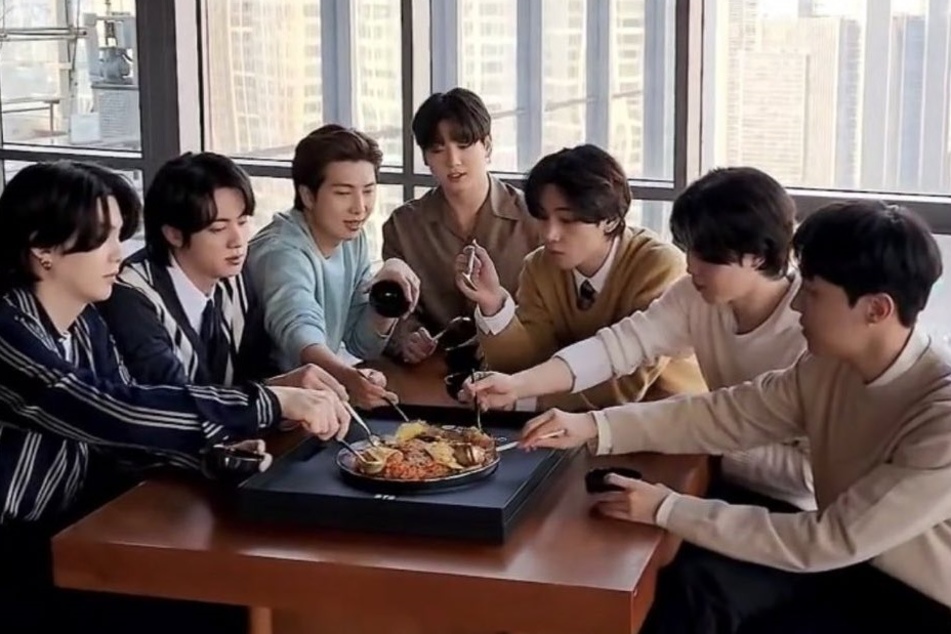 BTS celebrating the award by enjoying a traditional Korean meal called Bibimpap, which is steamed rice with a mix of vegetables and sometimes meat.