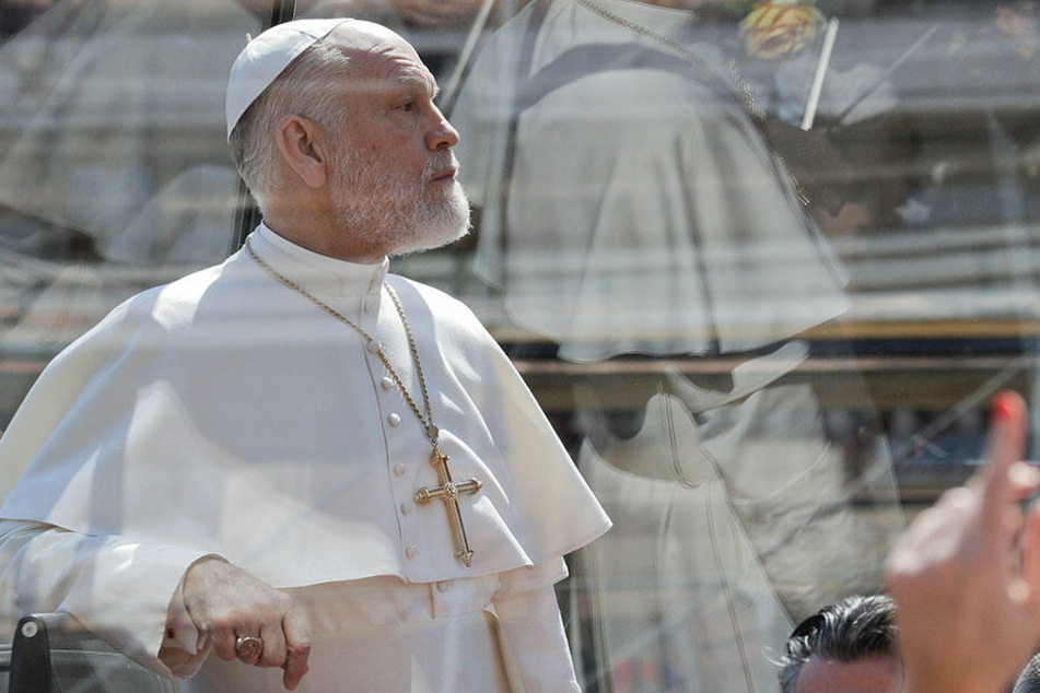 John Malkovich (65) fährt während der Dreharbeiten zu der Serie "The New Pope" von Regisseur Sorrentino in einem schwarzen Papamobil.