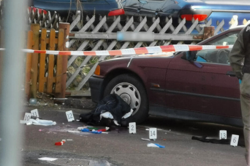 Markierungen der Polizei liegen nach der Messerstecherei neben einem Auto auf der Strasse.