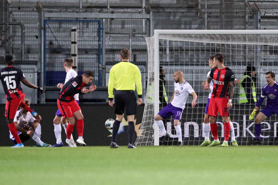 Das Siegtor für Wehen Wiesbaden! Paterson Chato (l.) trifft nach einem Eckball, Aues Keeper Martin Männel (r.) ist chancenlos.