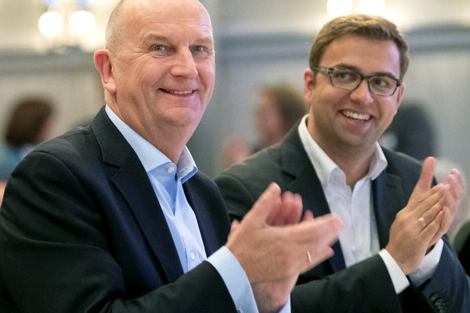Dietmar Woidke (l) und Erik Stohn applaudieren beim Landesparteitag der SPD Brandenburg nach Bekanntgabe der Ergebnisse der Abstimmung über den Koalitionsvertrag mit CDU und Bündnis 90/Die Grünen.