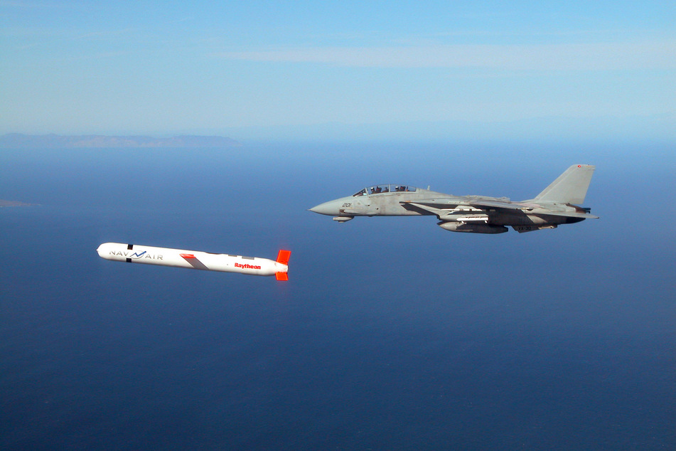 Ein F-15-Kampfjet fliegt neben einem Marschflugkörper vom Typ Tomahawk.