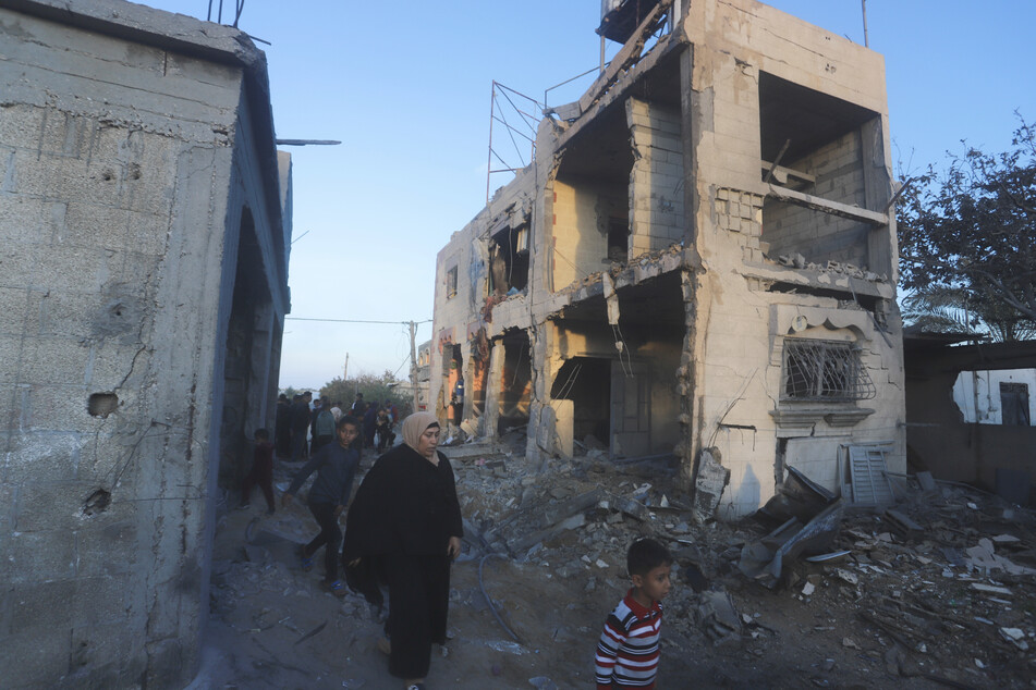 Palästinenser gehen an einem Wohnhaus vorbei, das bei einem israelischen Luftangriff zerstört wurde.