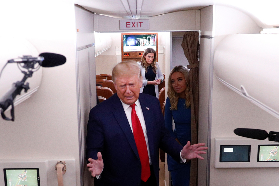 White House senior aide to Mark Meadows Cassidy Hutchinson (c.) and Press Secretary Kayleigh McEnany (r.) watch as ex-president Trump speaks to journalists aboard Air Force One.