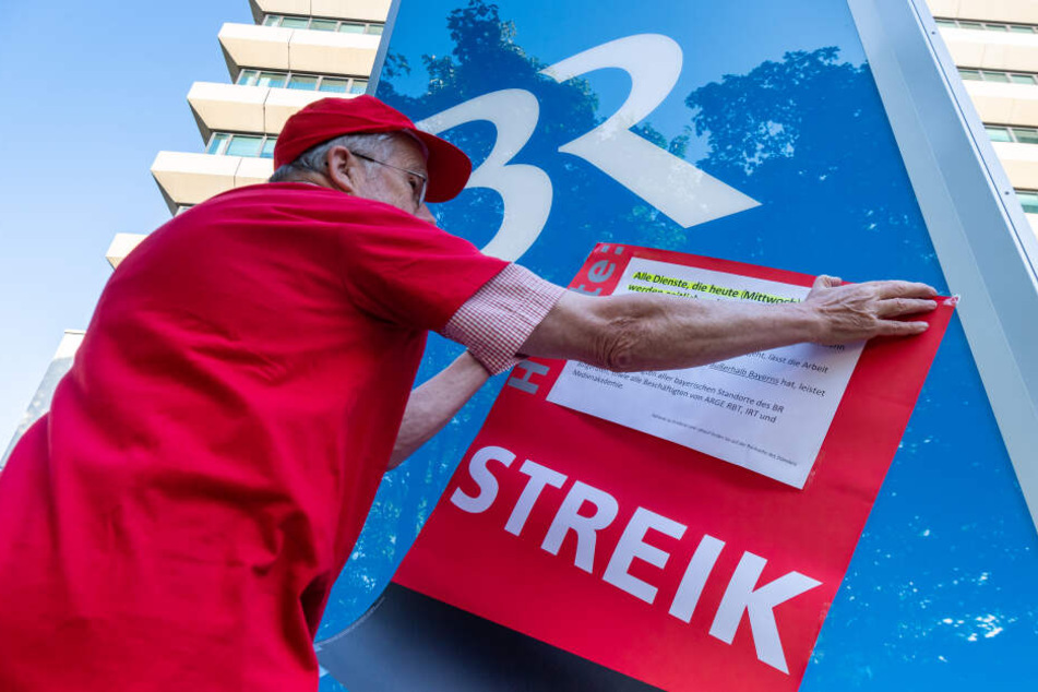 Ein Plakat mit der Aufschrift "Streik" wird vor dem Funkhaus des bayerischen Rundfunk aufgehängt