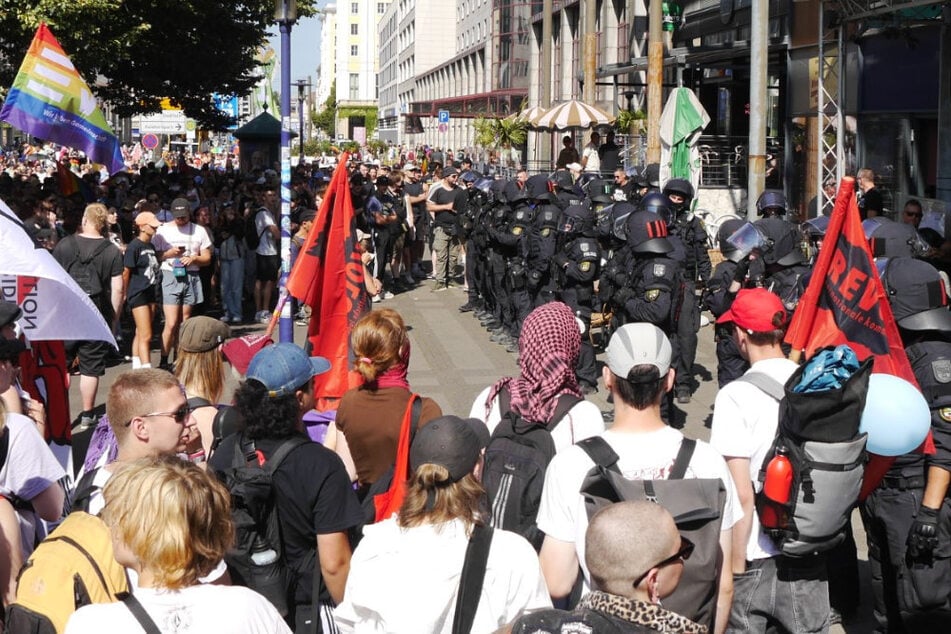 Bei einer Bar in der Leiterstraße bildeten Polizisten eine Wand, um Antifa-Angehörige von Teilnehmern der Gegendemo fernzuhalten. Die Gegendemonstranten zeigten der Menge lächelnd den Mittelfinger.