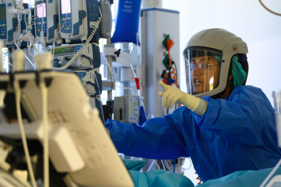Eine Fachärztin ist auf der Covid-19 Intensivstation mit der Versorgung eines Corona-Patienten beschäftigt.
