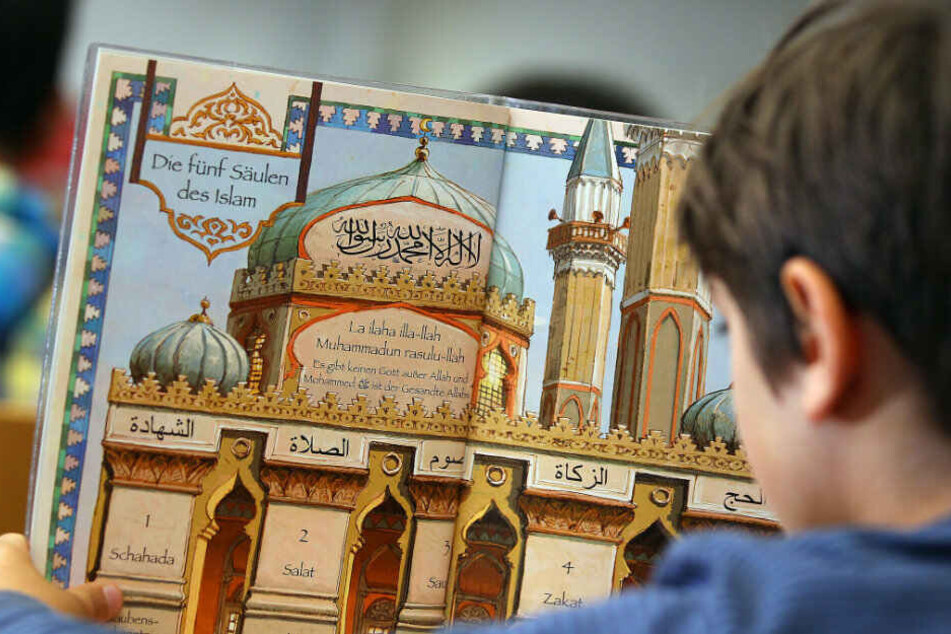 Ein Junge liest während des islamischen Religionsunterrichts in einem Schulbuch.
