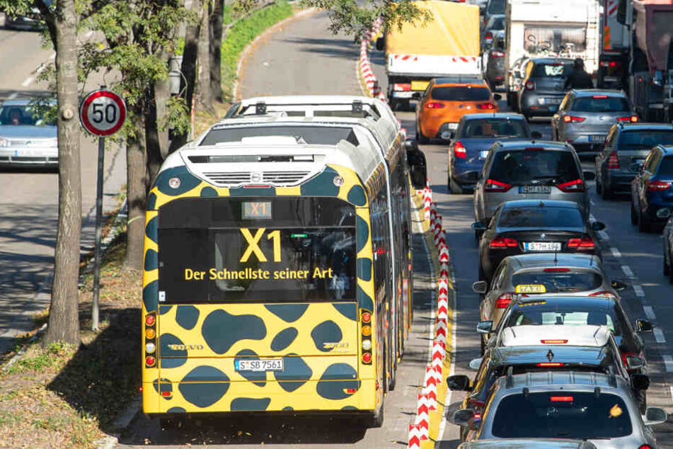 Der Schnellbus X1 fährt an stehenden Autos vorbei.