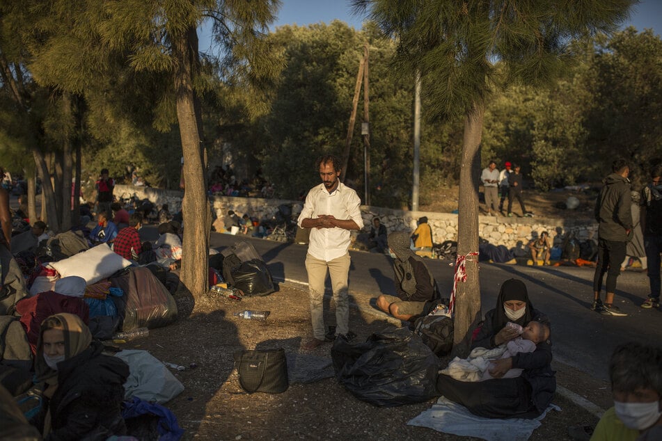 Ein Mann betet am Rande einer Straße in der Nähe des ausgebrannten Flüchtlingslagers Moria.