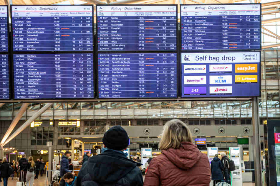 Passagiere informieren sich über die gestrichenen Flüge am Flughafen Hamburg.