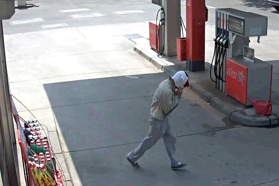 Der Tatverdächtige verlässt mit Maske die Tankstelle.