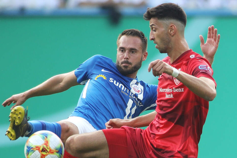 Rostocks Pascal Breier (l) kämpft mit Stuttgarts Atakan Karazor um den Ball.
