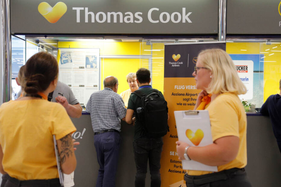 Am Schalter von Thomas Cook stehen Mitarbeiterinnen und kümmern sich um gestrandete Urlauber.