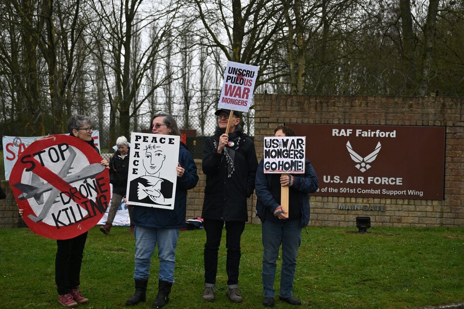 Anti-war protesters gather with placards at an entrance to RAF Fairford in south west England shortly after sunrise on Saturday.