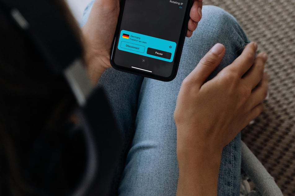 Person mit Kopfhörern nutzt Smartphone mit aktivierter VPN-Verbindung – idealer Einsatz eines VPN für die Schweiz