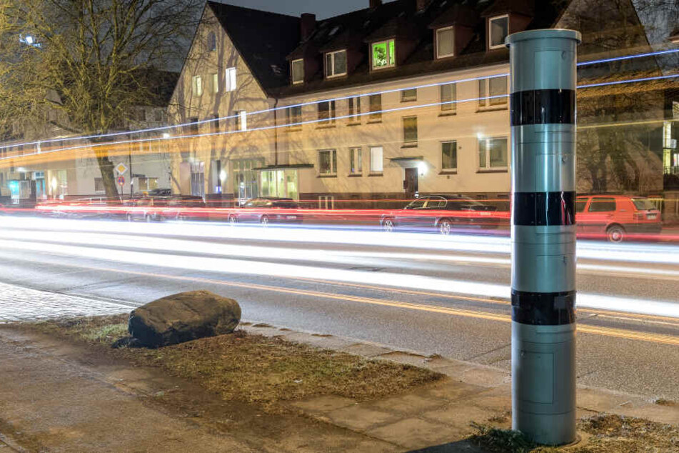 Fahrzeuge fahren an der Osterfeldstraße in Hamburg an einer Blitzersäule vorbei.