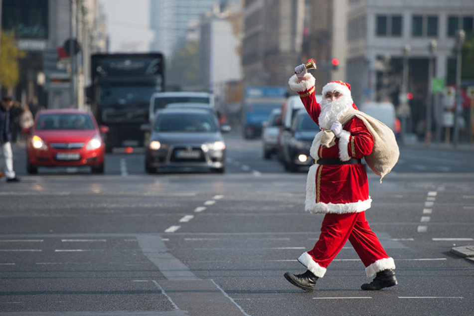 Student Lennart Neums aus Berlin geht als Weihnachtsmann verkleidet über eine Kreuzung am Potsdamer Platz in Berlin.