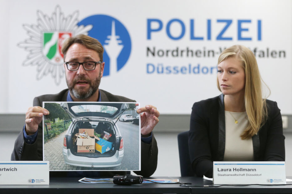 Polizei-Pressesprecher André Hartwich und Staatsanwältin Laura Hollmann zeigen ein Bild des Tatfahrzeugs.