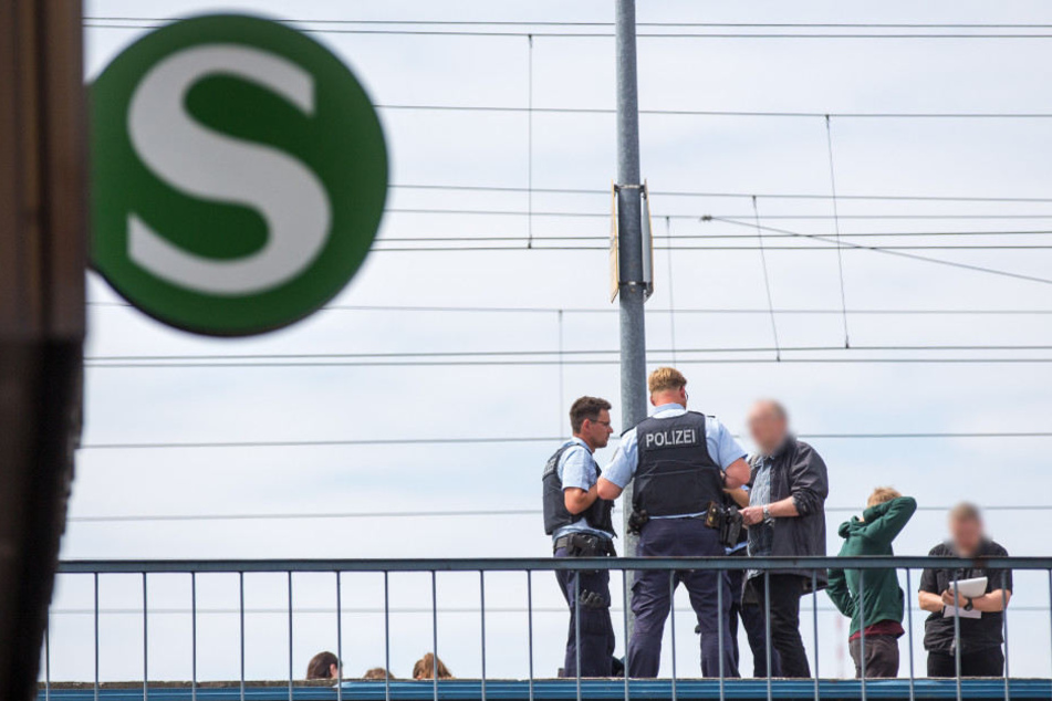 Polizisten und Ermittler in Zivil besprechen sich auf dem Bahnsteig des S-Bahnhofs.