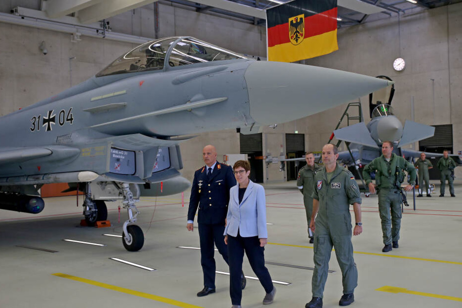 Annegret Kramp-Karrenbauer (M, CDU), Verteidigungsministerin, geht neben Ingo Gerhartz, Inspekteur der Luftwaffe (l) und Danilo Schlag, Kommodore des Taktischen Luftwaffengeschwarders 31 (r) an einem Eurofighter vorbei.