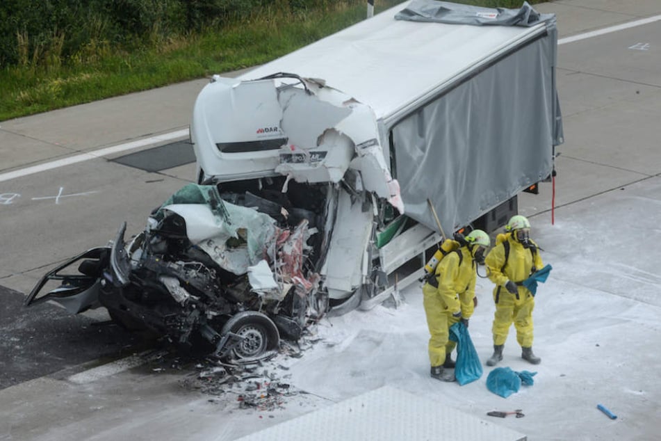 Feuerwehrmänner in Schutzanzügen an der Unfallstelle.