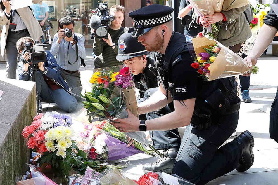 Britische Polizisten legen Blumen für die Opfer nieder.