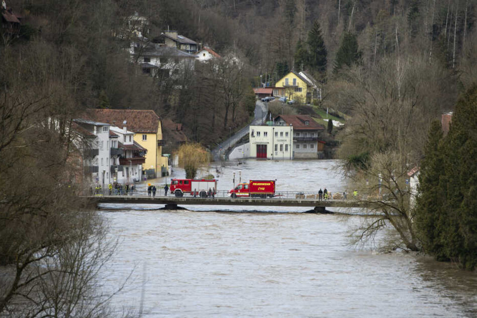 Feuerwehrfahrzeuge stehen auf der Ilzbrücke im Stadtteil Hals: Das Hochwasser hat in Teilen Passaus Straßen und Grundstücke überflutet und Keller volllaufen lassen.