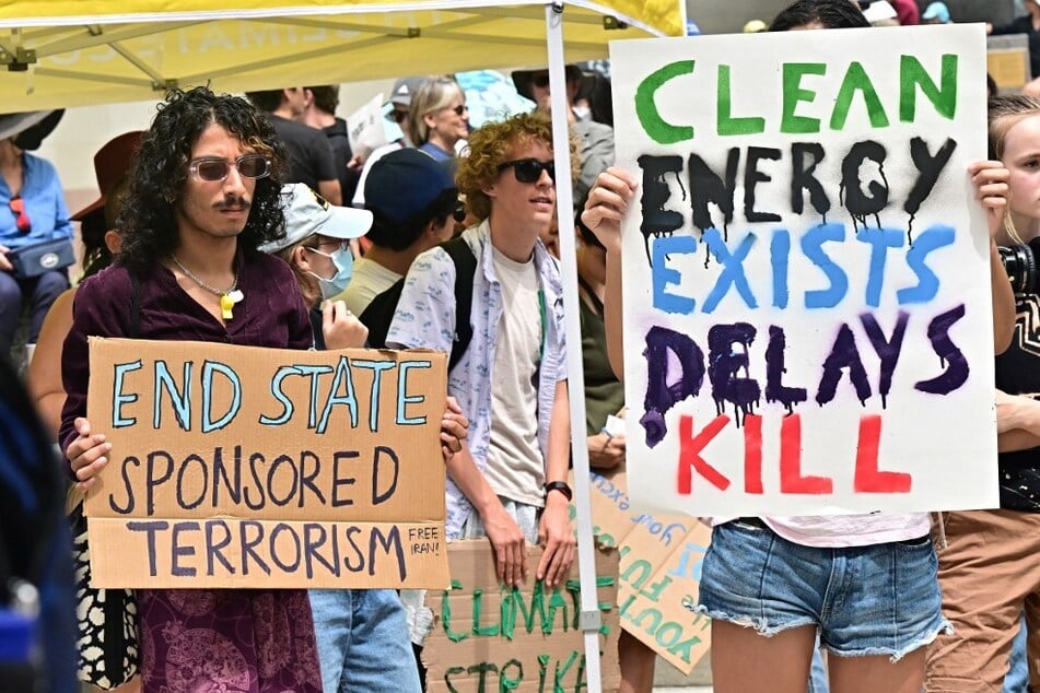 Activists hold signs while participating in a Climate Strike rally on September 15, 2023, in Los Angeles, California.