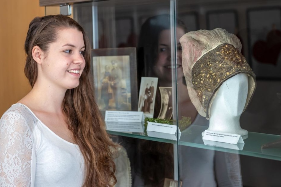 Studentin Hannah Stupp (22) betrachtet eine Damenhaube aus der Zeit um 1800.