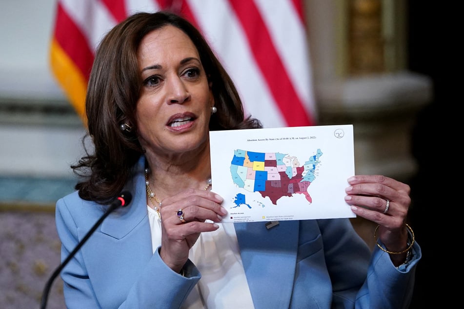 Vice President Kamala Harris holds up a map showcasing abortion access across the US.