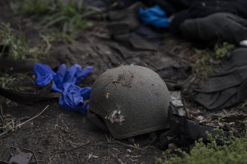 Ein beschädigter Helm liegt auf dem Boden an einer Stelle, an der die Leichen von vier ukrainischen Soldaten in einem Gebiet nahe der Grenze zu Russland in der Region Charkiw gefunden wurden.