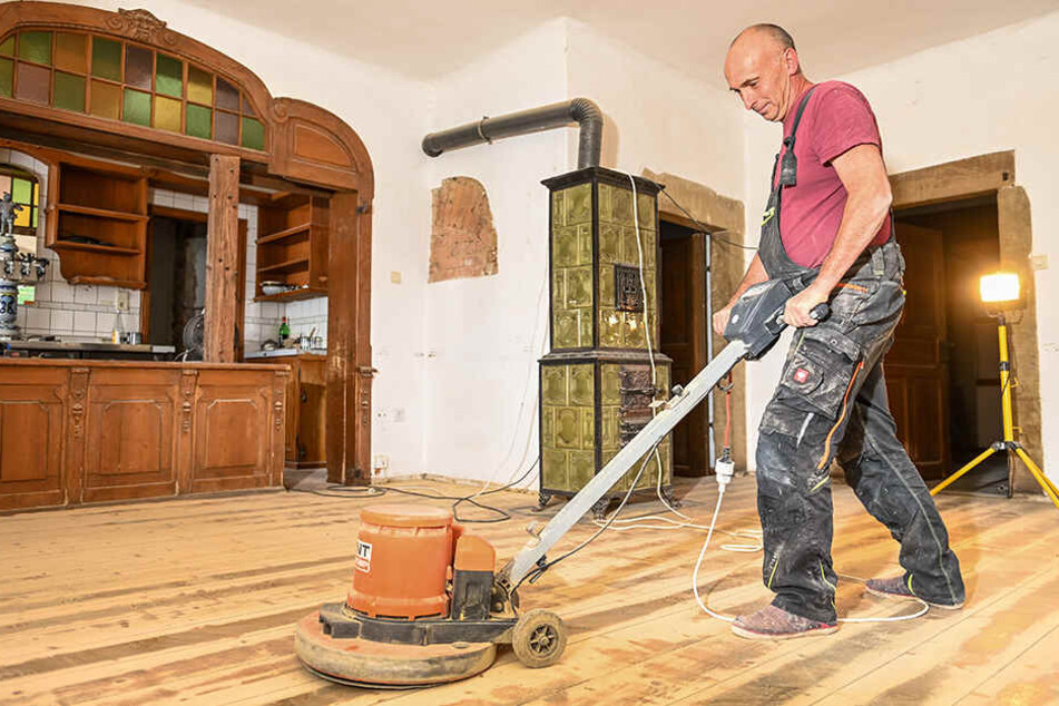Baudienstleister Uwe Schubert (55) schleift den alten Boden in den Räumlichkeiten ab.