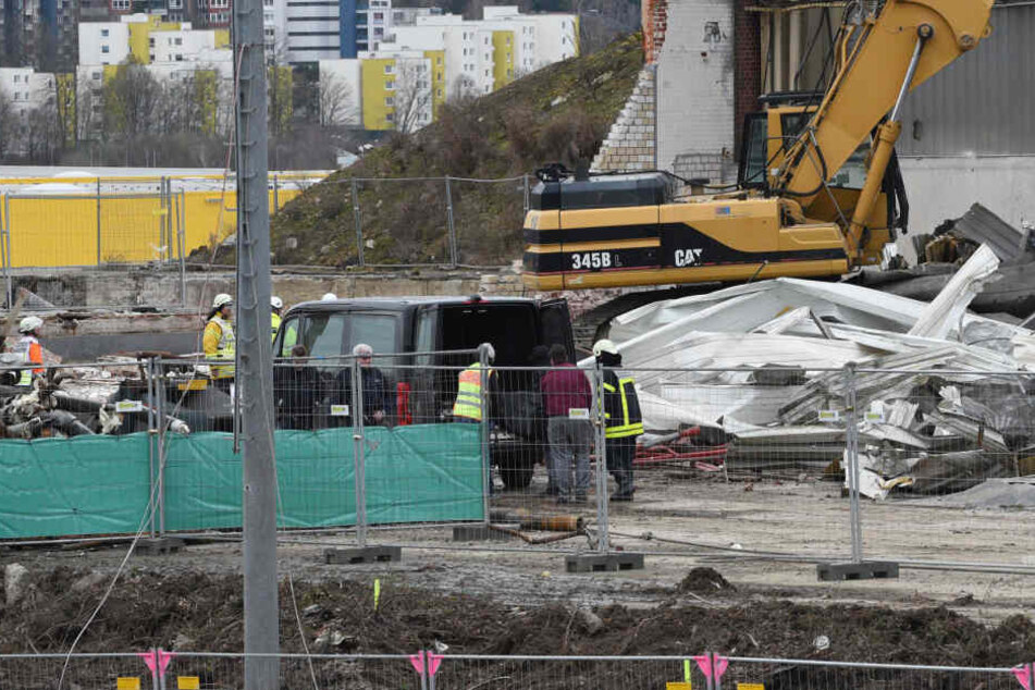 Feuerwehr und Rettungsdienste stehen nach dem Einsturz einer Ziegelwand, bei dem zwei Arbeiter ums Leben gekommen sind, an der Unglücksstelle.