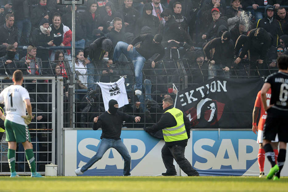Ein Cottbus-Randalierer setzt zum Schlag gegen einen Ordner an. (Archivbild)
