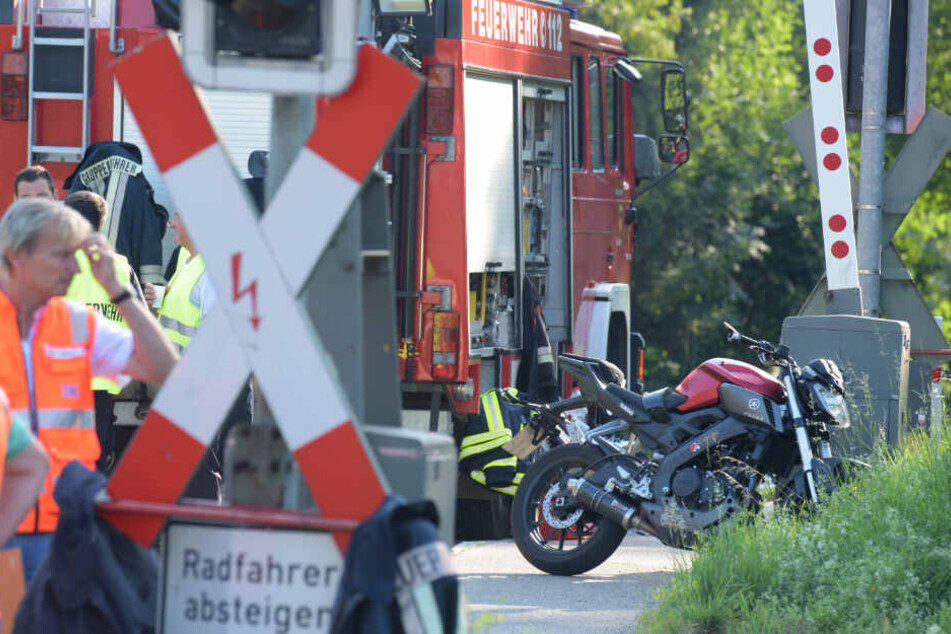 Ein verunglücktes Motorrad steht an einem Bahnübergang im bayerischen Harburg. Der Motorradfahrer wurde von einem Zug erfasst und tödlich verletzt.